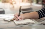 Woman Hand Writing On Notepad Stock Photo