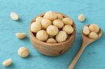 Macadamia In Bowl On Blue Table Stock Photo