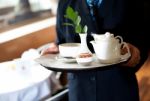 Butler Holding Tea Tray For Guest Stock Photo