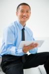 Close-up Of Smiling Businessman Sitting Stairs Holding Digital T Stock Photo