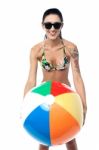 Bikini Clad Woman Playing With Beach Ball Stock Photo