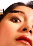 Girl Applying Mascara Stock Photo