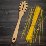 The Thin Spaghetti On Black Wooden Background. Yellow Italian Pa Stock Photo