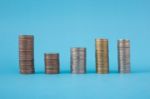 Stack Of Coins On Blue Soft Background Stock Photo