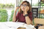 A Young Lady Wears Glasses Working On Laptop And Thinking About Stock Photo