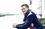 Handsome Man Leaning On Railing At River Stock Photo