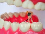 Miniature Worker On Plastic Teeth Of Removable Denture. Dental H Stock Photo