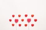 Pink Valentine's Day Heart Shape Lollipop With Small Red Candy In Cute Pattern On Empty White Paper Background. Love Concept. Colorful Hipster Style. Knolling Top View Stock Photo