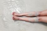 Leg Or Bare Woman Feet In The Ocean On Sand Beach Stock Photo