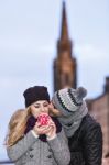 Young Couple In Love Embracing And Drinking Hot Drink From Red C Stock Photo