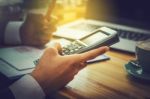 Business Man Sitting On A Calculator To Figure Out In A Coffee S Stock Photo