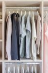 Clothes Hanging In Wooden Wardrobe Stock Photo