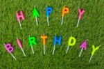 Colorful Happy Birthday Candles On Field Stock Photo