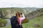 Woman Holding Smartphone Against Mountain Background. Ecology Concept Stock Photo