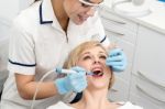 Female Dentist Inspecting Teeth Of Patient Stock Photo