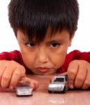 Boy Playing With Toy Cars On A Table Stock Photo