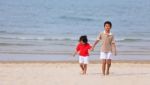 Asian Boys Holding Hands On Beach Stock Photo