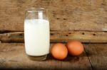 Glass With Milk And Egg On The Wooden Background Stock Photo