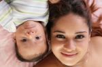 Portrait Of A Beautiful Hispanic Happy Mother With Baby Lying Do Stock Photo