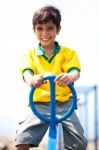 Young Kid Enjoying Swing Ride Stock Photo