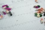 Heap Of Medicine Pills On Cardiogram Grid Paper. Selective Focus Stock Photo