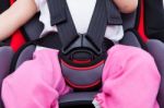 Girl Sitting At Carseat And Fasten Seat Belt. Concept About The Safety Of Traveling By Car Stock Photo