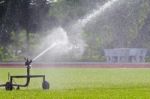 Sprinkler Watering The Grass Stock Photo