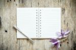 Blank Notebook With Orchids Purple Flowers On Wooden Table Stock Photo