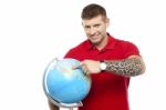 Guy Holding And Pointing Globe Stock Photo