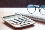 Calculator With Eyeglasses On Wooden Table Stock Photo