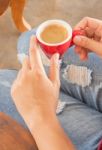 Woman In Torn Jeans Sitting At Coffee Shop Stock Photo