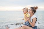 Asian Boy Chilling On The Beach With His Mother Stock Photo