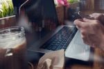 Businessman Is Working With His Computer In Coffee Shop With Sto Stock Photo