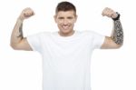 Muscular Young Man Showing Biceps Stock Photo