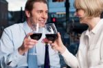 Happy Couple Raises A Glass Of Red Wine Stock Photo