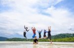 Happy Family Jumping Together On The Beach, Thailand Stock Photo