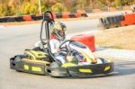 Little Girls Are Driving Go- Kart Car In A Playground Racing Track Stock Photo