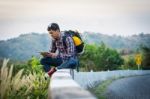 Tourists Man Look At A Map On The Tablet On Mountain Roads Stock Photo