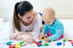 Baby Girl And Her Mother Playing At Home Stock Photo