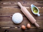 Raw Pizza Dough And Rolling Pin On Wooden Background Stock Photo