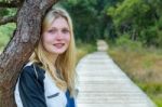 Portrait Of Blonde Girl With Trunk And Path In Nature Stock Photo