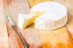 Camembert Cheese With Cut Wedge And Vintage Knife On Wooden Tabl Stock Photo