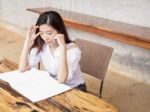 Young Woman Reading Book Or Magazine On Wood Table Stock Photo