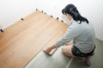 Beautiful Woman Puts Laminate Flooring Stock Photo