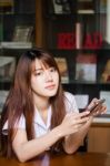 Portrait Of Thai Adult Student University Uniform Beautiful Girl Using Her Smart Phone Stock Photo