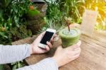 Hand Hold Cool Green Tea And Smartphone Stock Photo