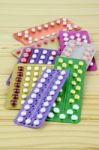 Colorful Oral Contraceptive Pill Strips On Pine Wood Table Stock Photo