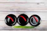 Red Hot Chilli Pepper And Scallions On Plate Stock Photo