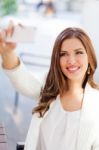 Portrait Of A Young Woman Taking A Picture With Her Cell Phone Stock Photo