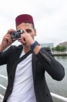 Young Man With A Fez Cap Taking A Photo Stock Photo